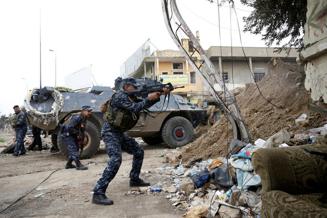 REFILE - CORRECTING GRAMMAR A member of the Iraqi Federal Police fires an assault rifle during combat against the Islamic State in western Mosul, Iraq, April 13, 2017. REUTERS/Andres Martinez Casares