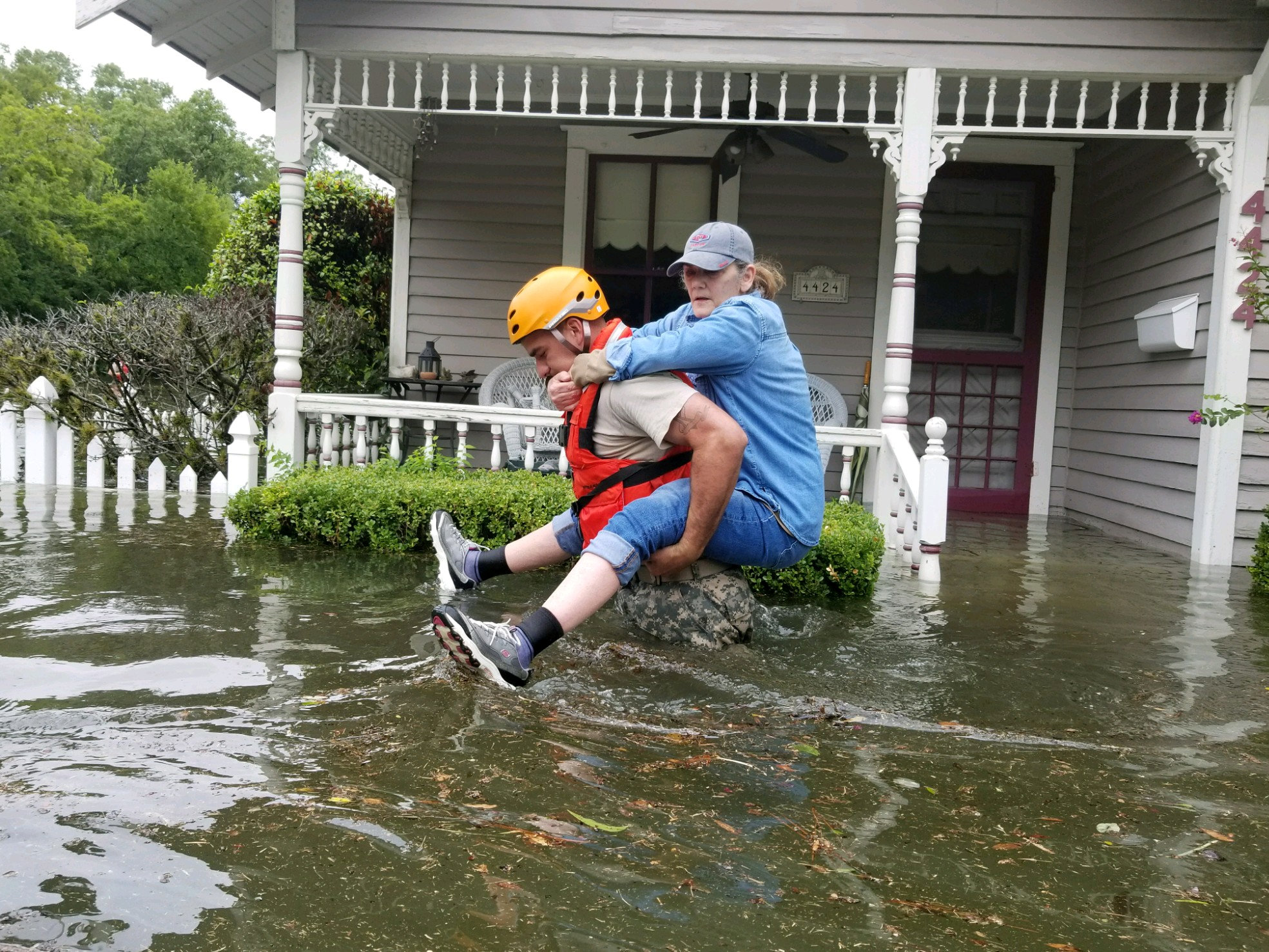 A Texas National Guard soldier carries a woman on his bank as they conduct rescue operations in flooded areas around Houston, Texas, U.S., August 27, 2017. 1Lt. Zachary West, 100th MPAD/Texas Military Department/Handout via REUTERS ATTENTION EDITORS - THIS IMAGE WAS PROVIDED BY A THIRD PARTY