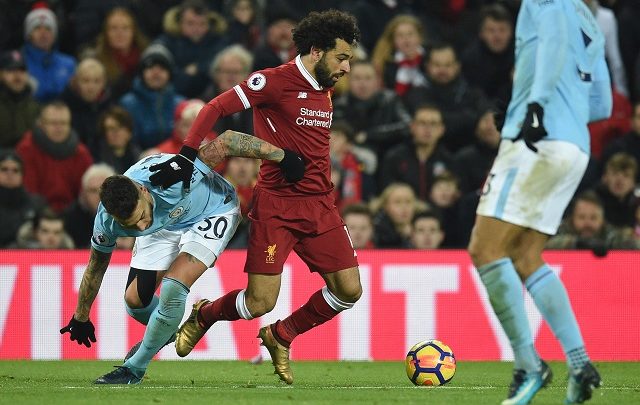 Liverpool's Egyptian midfielder Mohamed Salah (C) tangles with Manchester City's Argentinian defender Nicolas Otamendi (L) during the English Premier League football match between Liverpool and Manchester City at Anfield in Liverpool, north west England on January 14, 2018. - RESTRICTED TO EDITORIAL USE. No use with unauthorized audio, video, data, fixture lists, club/league logos or 'live' services. Online in-match use limited to 75 images, no video emulation. No use in betting, games or single club/league/player publications. / AFP / Oli SCARFF / RESTRICTED TO EDITORIAL USE. No use with unauthorized audio, video, data, fixture lists, club/league logos or 'live' services. Online in-match use limited to 75 images, no video emulation. No use in betting, games or single club/league/player publications.