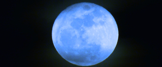 Blue full moon on black sky in the winter.