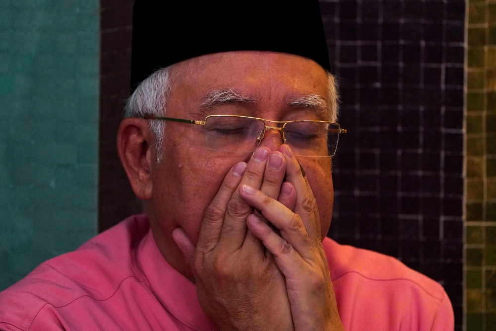 FILE PHOTO: Malaysia’s former Prime Minister Najib Razak prays before he attends the United Malays National Organisation (UMNO) 72th anniversary celebrations in Kuala Lumpur, Malaysia May 11, 2018. REUTERS/Athit Perawongmetha/File Photo