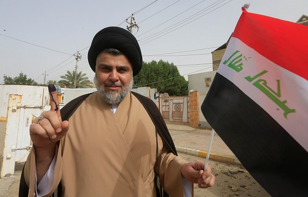 Iraqi Shi'ite cleric Moqtada al-Sadr shows his ink-stained finger after casting his vote at a polling station during the parliamentary election in Najaf, Iraq May 12, 2018. REUTERS/Alaa al-Marjani