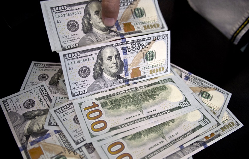 An employee counts US dollars at a bureau de change in downtown Rio de Janeiro, Brazil, on September 10, 2015. The Brazilian real devaluated Thursday 1.92% against the US dollar. Brazil was downgraded by Standard & Poor's financial services company and lost its investment-grade credit rating. AFP PHOTO/VANDERLEI ALMEIDA