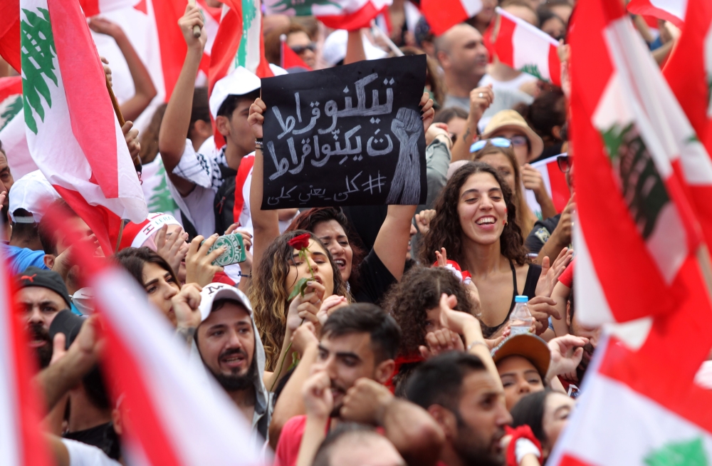 Lebanese protesters rally in downtown Beirut on the fourth day of demonstrations against tax increases and official corruption, on October 20, 2019. - Tens of thousands of people took to the streets for a fourth day of protests against tax increases and alleged official corruption. The protesters took to the streets despite calls for calm from politicians and dozens of arrests on Friday. Many waved billowing Lebanese flags and insisted the protests should remain peaceful and non-sectarian. The demonstrators are demanding a sweeping overhaul of Lebanon's political system, citing grievances ranging from austerity measures to poor infrastructure. (Photo by IBRAHIM AMRO / AFP)