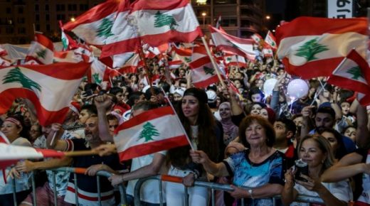 epa07986927 Protesters wave Lebanese flags, dance on national songs during ongoing anti-government protests in front the Al-Ameen mosque in downtown Beirut, Lebanon, 10 November 2019. Protesters demand the president make parliamentary consultations immediately to facilitate the formation of a new government that replaces the recently resigned Cabinet. They also demand the formation of a technocratic government with no political affiliation. Saad Hariri resigned as Prime Minister on 29 October, bringing down the entire Cabinet. EPA/NABIL MOUNZER