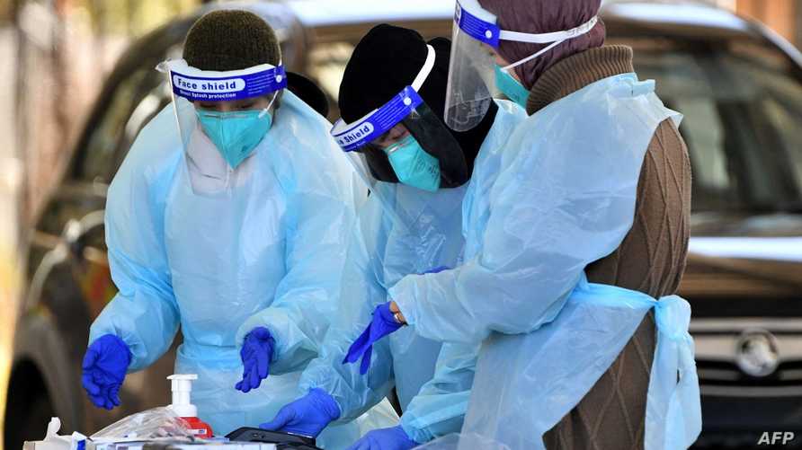 This picture taken on July 28, 2021 shows health workers taking swab samples from residents at a Covid-19 drive-through testing clinic in Sydney as millions of residents will spend another month in lockdown citing a still-fast-growing coronavirus outbreak and stubbornly low vaccination rates. (Photo by Saeed KHAN / AFP)