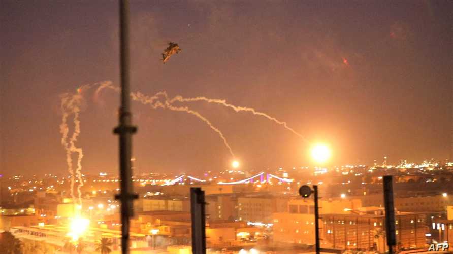 A handout picture received from the US embassy in Iraq on December 31, 2019, shows a US army apache helicopter dropping flares over Baghdad's high-security Green Zone on December 31, 2019, after Iraqi supporters of pro-Iran factions breached the outer wall of the US embassy over weekend air strikes that killed pro-Iran fighters in western Iraq. - The US State Department said that embassy personnel are safe and there are no plans to evacuate, after Iraqi supporters of pro-Iran factions attacked the compound. It is the first time in years that protesters have been able to reach the building, sheltered behind a series of checkpoints in the high-security Green Zone. (Photo by - / US EMBASSY IN IRAQ / AFP)