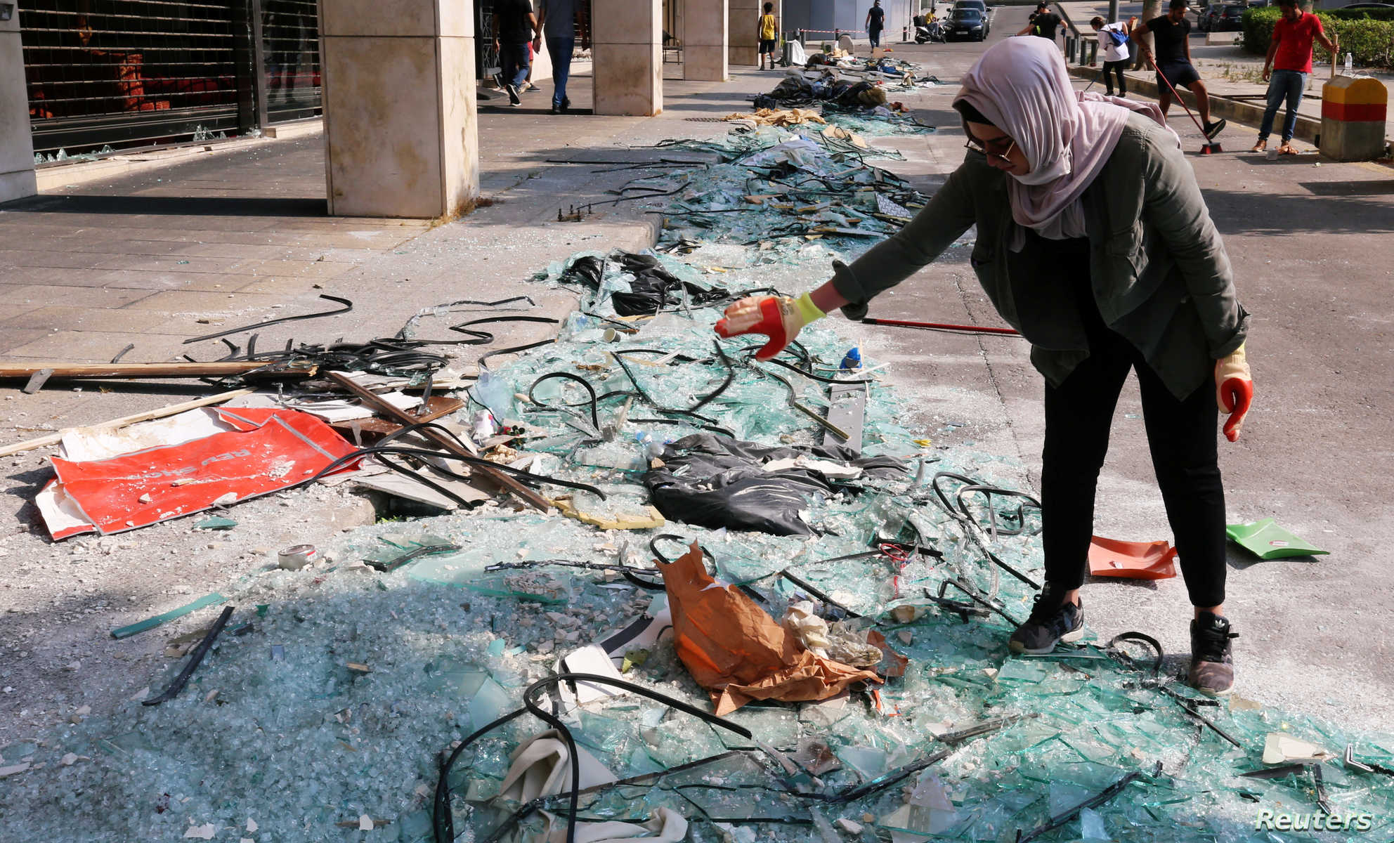 A woman stands near broken glass following Tuesday's blast in Beirut's port area, in Beirut, Lebanon August 7, 2020. REUTERS/Aziz Taher