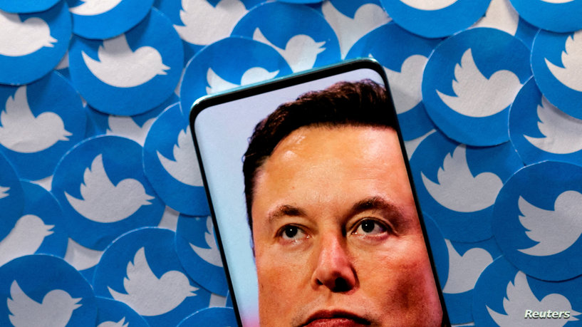 FILE PHOTO: An image of Elon Musk is seen on smartphone placed on printed Twitter logos in this picture illustration taken April 28, 2022. REUTERS/Dado Ruvic/Illustration//File Photo